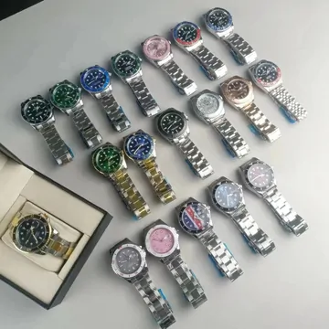 A table covered with steel wristwatches with dials in green, pink, blue and white.